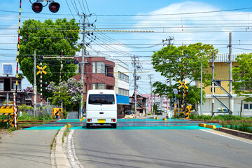 住宅地の踏切を通過する自動車