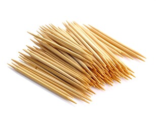 Close-up studio shot of a pile of small, wooden toothpicks