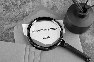 A magnifying glass highlights the phrase innovation power, accompanied by envelopes and a simple black container, creating an atmosphere of creativity and future planning