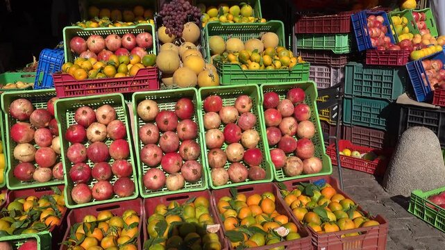 Tunis, Tunisia A display of fruit like oranges and pomegranates at an outdoor fruit stand. 