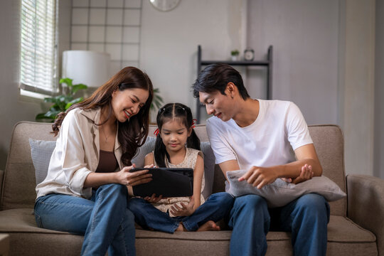 Asian family using digital tablet for learning at home