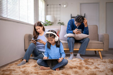 Family ignoring each other engrossed in digital devices at home
