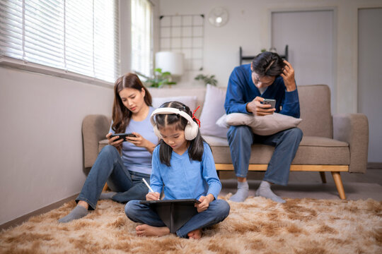 Family ignoring each other engrossed in digital devices at home