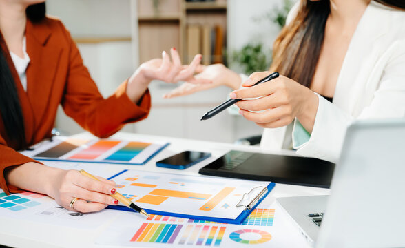 Creative female designers team using pen tablet and color palette working in graphic design Choose colors for working on tablets and computer designs.