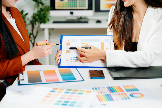 Creative female designers team using pen tablet and color palette working in graphic design Choose colors for working on tablets and computer designs.