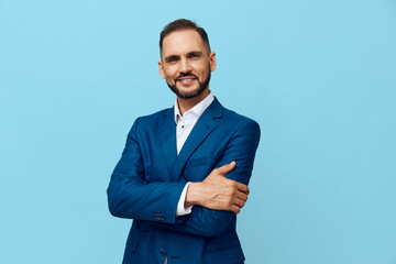 A professional businessman stands against a solid blue background, projecting confidence, calm, and assurance. The isolated color highlights focus and authority.
