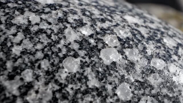 Close up view of smooth granite boulder surface with crystals