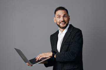 A professional businessman holds a laptop and smiles confidently against a solid colored background. The image conveys optimism, focus, and energy, highlighting leadership and modern corporate ethos.
