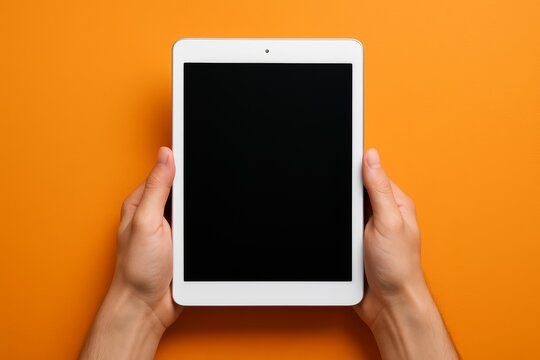 Person holding digital tablet with blank screen on vibrant orange background, minimalistic creatyve concept for technology or app showcase. Ai generative - Powered by Adobe