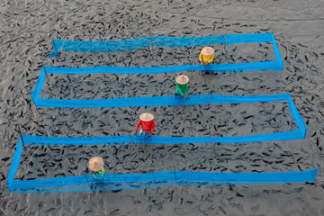 Unidentified fishermen arranging colourful fish nets. Top view, selective focus