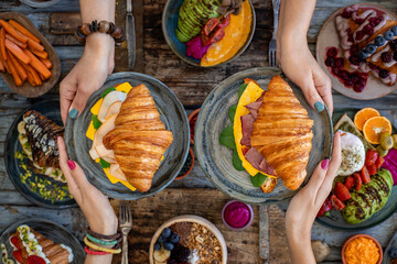 Croissant sandwich filled with ham, bacon, cheese and salad.  croisandwich