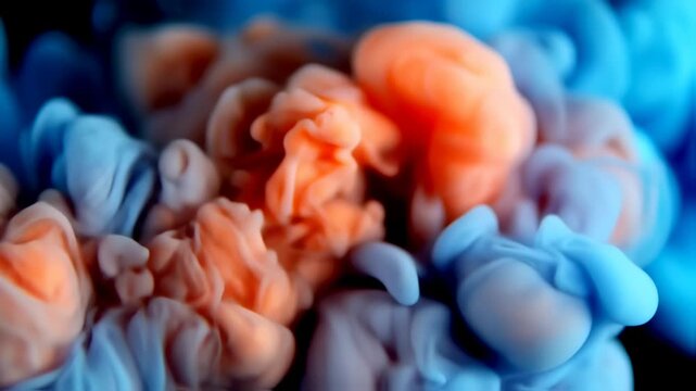 Abstract swirls of vibrant blue and orange ink dissolving in a dark liquid