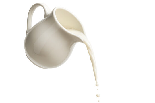 White ceramic pitcher pouring milk with drops falling