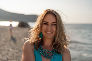 Woman beach summer, happy young woman on summer vacation smiles genuinely on a sunny beach at golden hour, natural beauty.