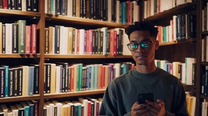 Young man reads and explores books in a library surrounded by colorful shelves - Powered by Adobe