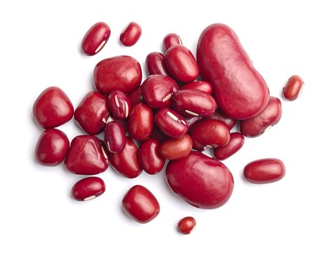 Close-up of various red, kidney-shaped beans on white background