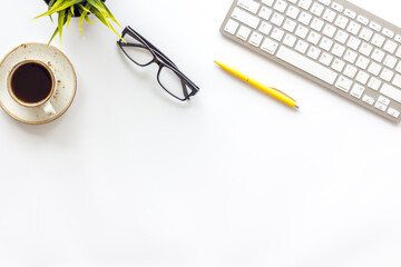 Home office workspace with computer keyboard and cup of coffee on white background, top view. Education online. Tabletop of freelancer.