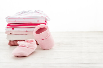 Pile of washed baby clothes with booties on a table, close up