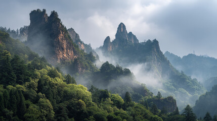 A scenic view of jagged mountain peaks shrouded in mist and lush green vegetation
