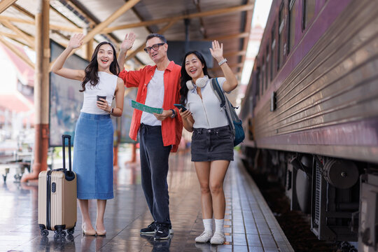 Diverse friends enjoying train travel, waving at station