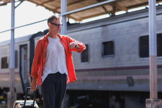 Traveler checking wristband for time on train platform