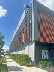 Corner of a modern warehouse unit complex with a foot path and garden