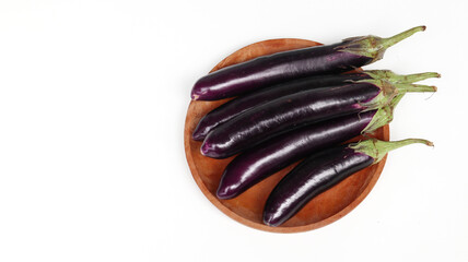 fresh raw healthy eggplants or aubergine vegetable on wooden plate. Food ingredient, vegetatian cuisine, organic greenhouse farm plant