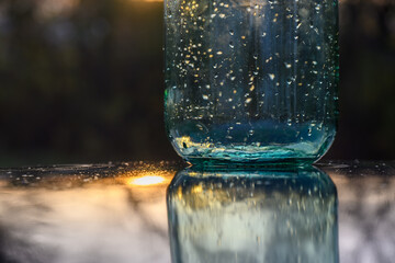 An empty glass jar at sunrise.