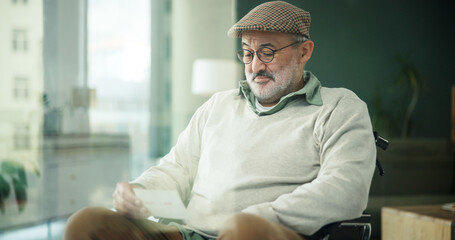 Happy, photograph and senior man in wheelchair for nostalgia, reflection or memory with relaxing....