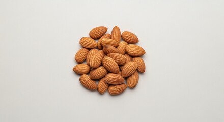 A centered pile of almonds with textured shells on a plain light background in a studio setting view
