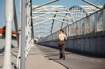 Woman Jogging on Urban Bridge