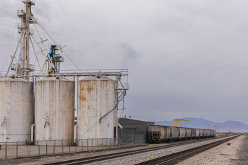 Obraz premium Grain silos next to train tracks in rural western landscape
