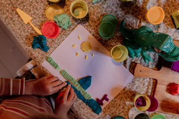Child crafting sun and shapes with colorful playdough