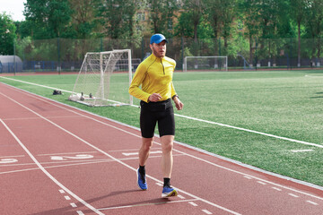 Obraz premium Runner passing football goal at stadium