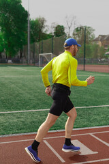 Obraz premium Runner jogging near football field