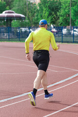 Obraz premium Man jogging at the stadium, rear view