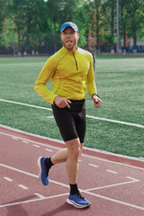 Obraz premium Runner sticking out tongue during training on stadium