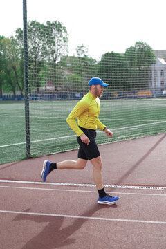 Man running in front of stadium fence