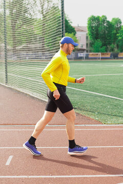 Man jogging on sunny day at stadium