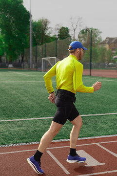 Runner jogging near football field