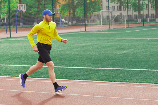 Male runner speeding up on track