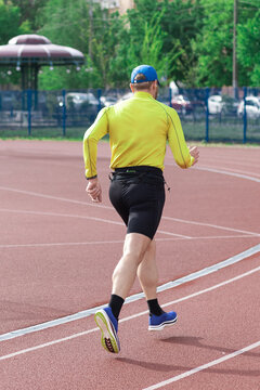Man jogging at the stadium, rear view