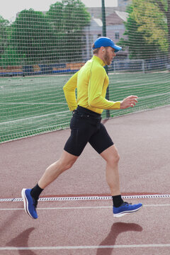 Man in motion running on stadium track