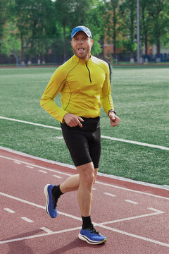 Runner sticking out tongue during training on stadium