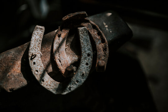 Rusty horseshoes resting on a blacksmith's anvil