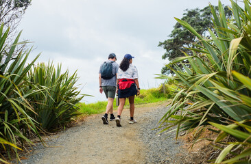 Couple walking on the Long Bay coastal track. Auckland.