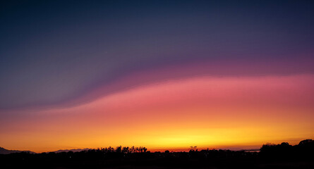 Stunning colorful sky at sunrise with warm tones and soft clouds over the horizon. Perfect for concepts of hope, inspiration, beauty, and the beginning of a new day.