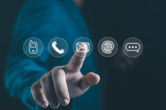 Businessman finger touching virtual contact icons including phone, email, and chat symbols, representing online communication, digital connection, and modern customer service technology.