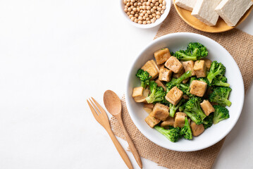 Stir fried tofu and broccoli with soy sauce in bowl on white background, Asian vegan food, Top view