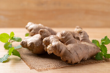 Fresh ginger with mint leaf on wooden background
